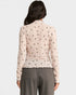 Woman wearing a patterned blouse and gray pants on a white background