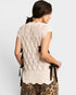 Woman wearing a beige lace top with a leopard print skirt on a white background