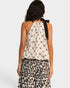 Woman wearing a patterned top and leopard print pants on a white background