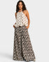 Woman wearing a halter top and leopard print pants on a white background