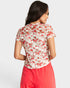 Woman wearing a floral blouse and pink pants on a white background