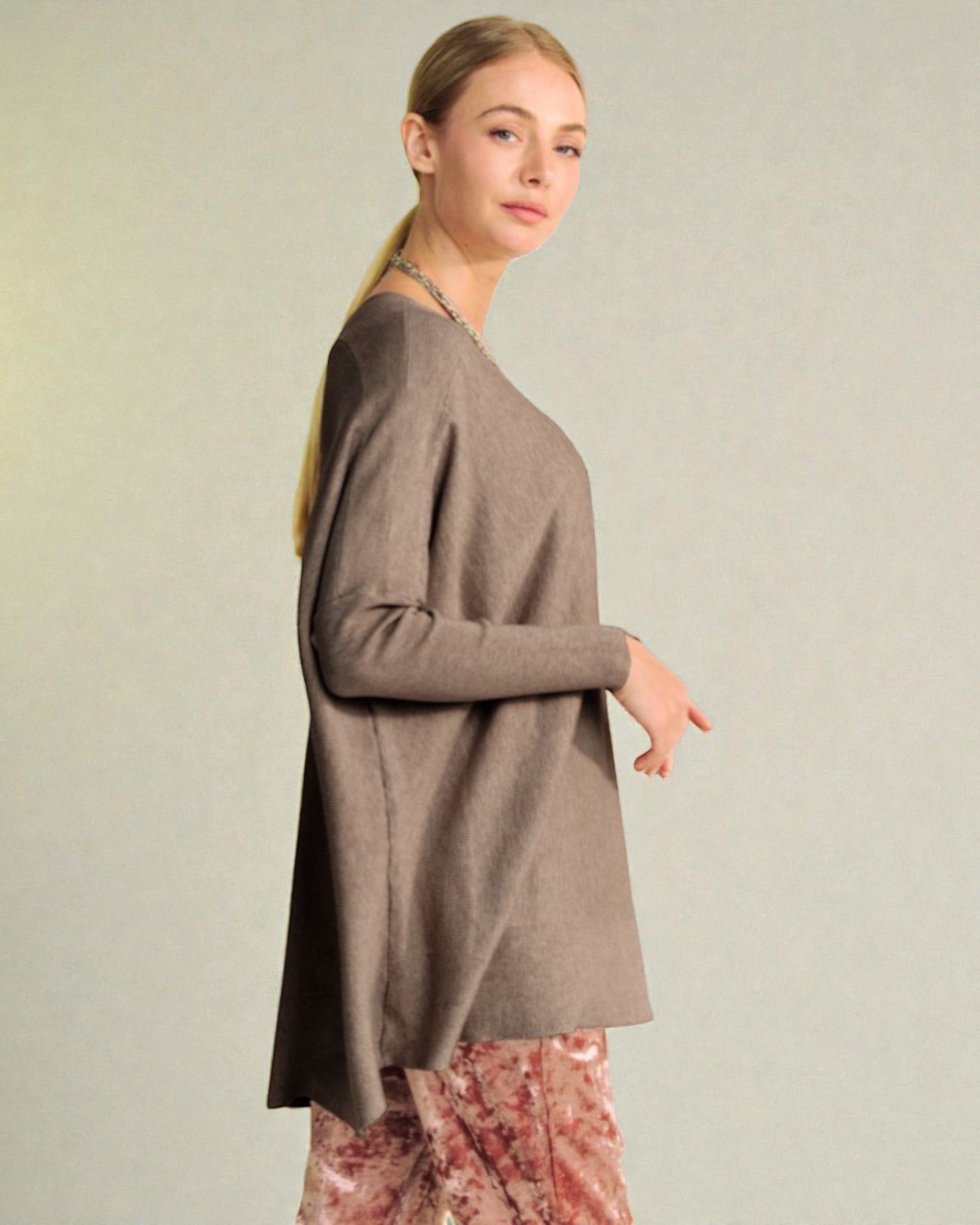 Woman wearing a brown sweater against a plain background