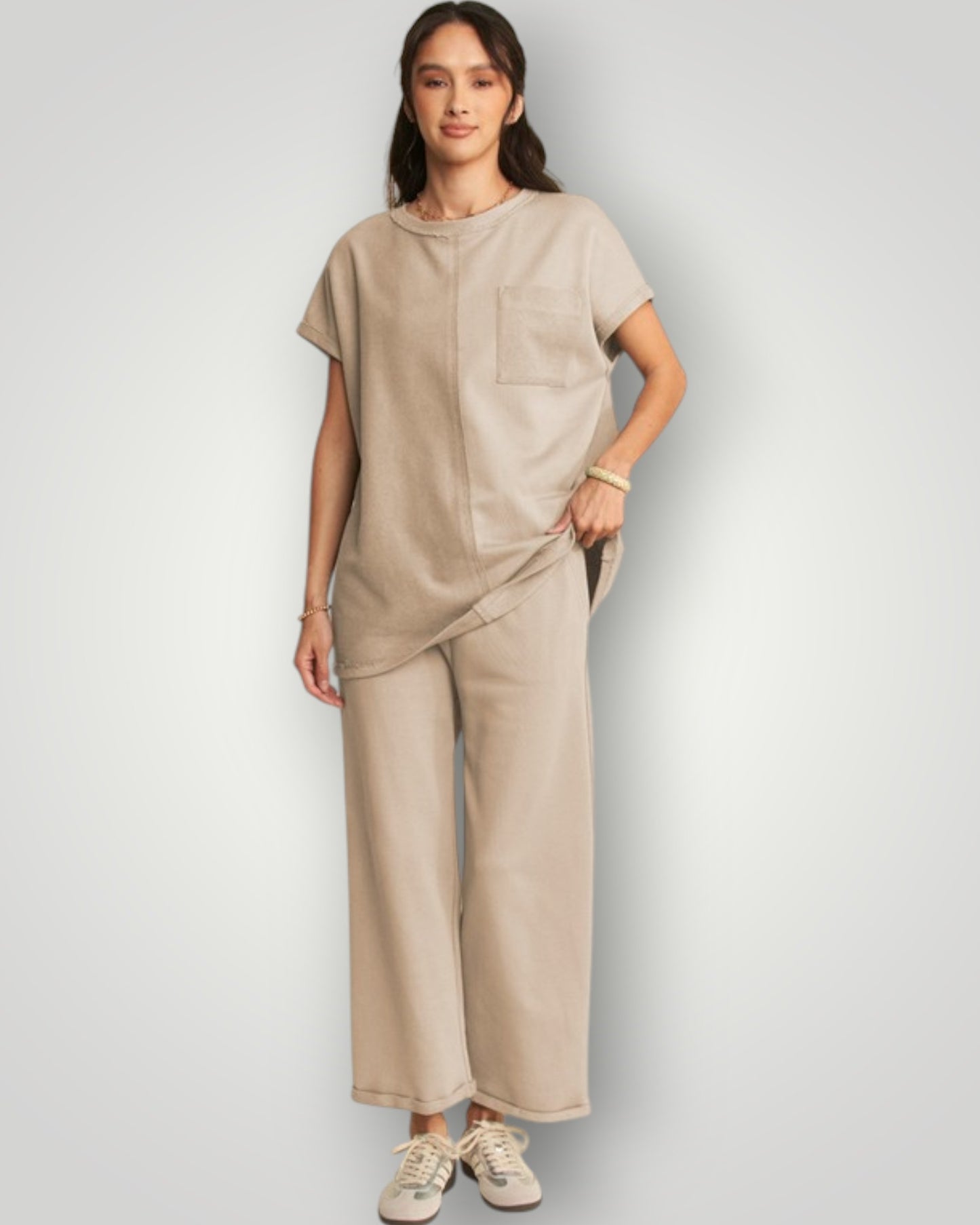 Woman wearing a beige outfit on a plain background