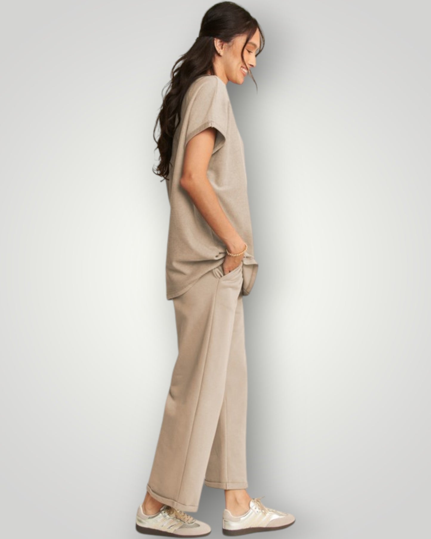 Woman wearing a beige outfit against a plain background