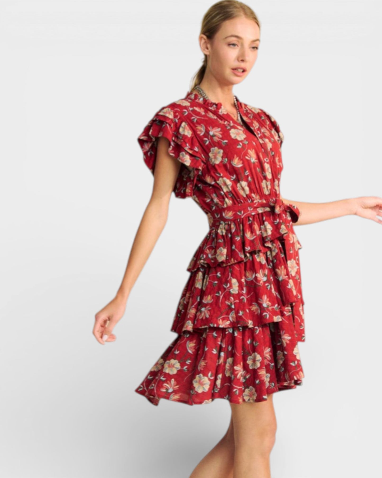 Woman wearing a red floral dress on a light gray background