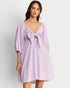 Woman wearing a light purple dress with a knot detail on a white background
