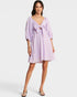 Woman wearing a light purple dress with a bow detail on a white background