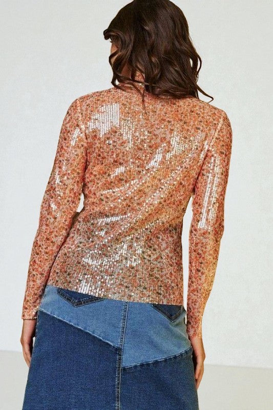 Person wearing a sequined top and denim skirt against a white background
