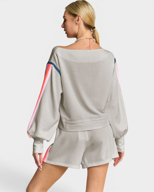 Woman wearing a gray outfit with colorful sleeves on a white background