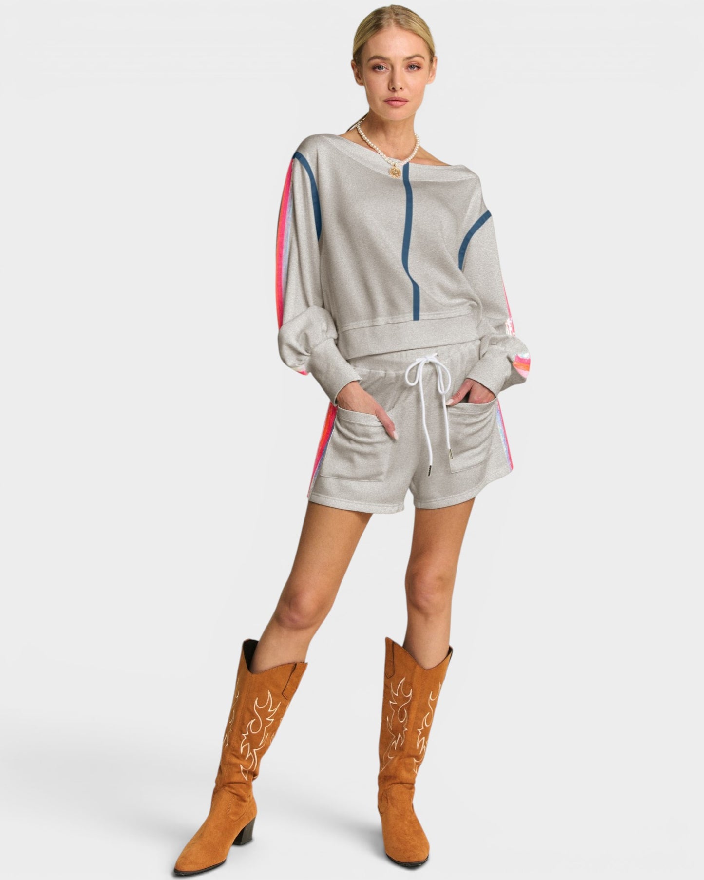 Woman wearing a gray outfit with colorful accents and brown boots on a white background