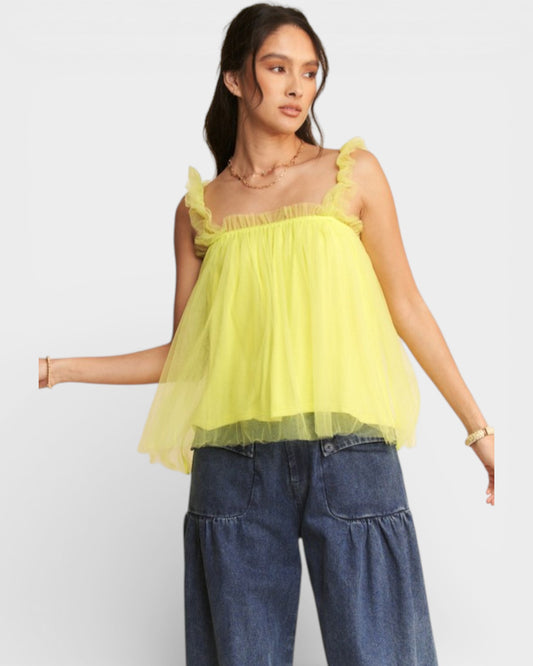 Woman wearing a yellow top and blue jeans on a white background