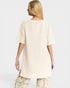 Woman wearing a beige oversized shirt with a plain background