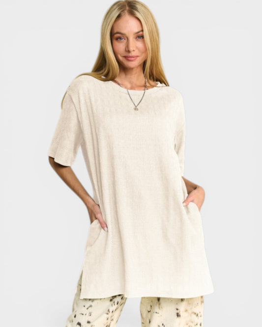 Woman wearing a beige oversized t-shirt on a white background