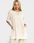 Woman wearing a beige oversized t-shirt on a white background