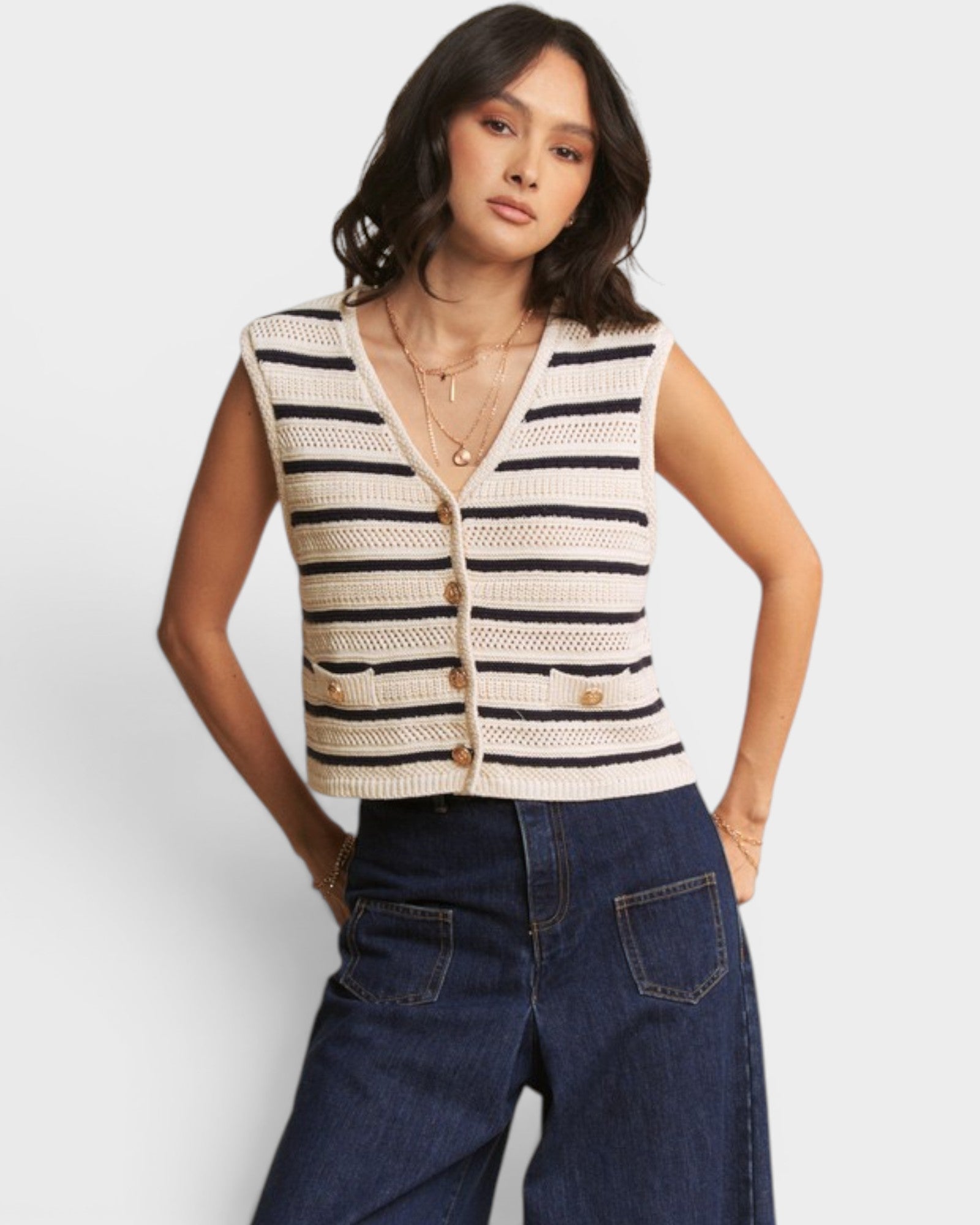 Woman wearing a striped vest and jeans on a white background