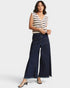 Woman wearing a striped top and wide-leg jeans on a white background