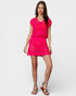 Woman wearing a bright pink outfit on a white background