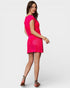 Woman wearing a bright pink dress on a white background