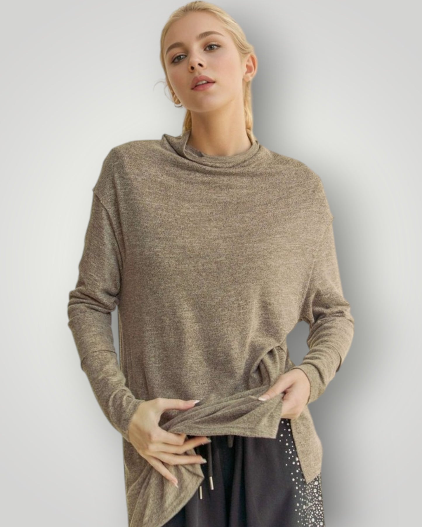 Woman wearing a brown turtleneck sweater against a plain background