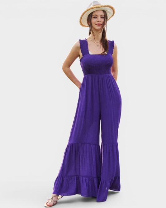 Woman wearing a purple dress with ruffled layers on a white background