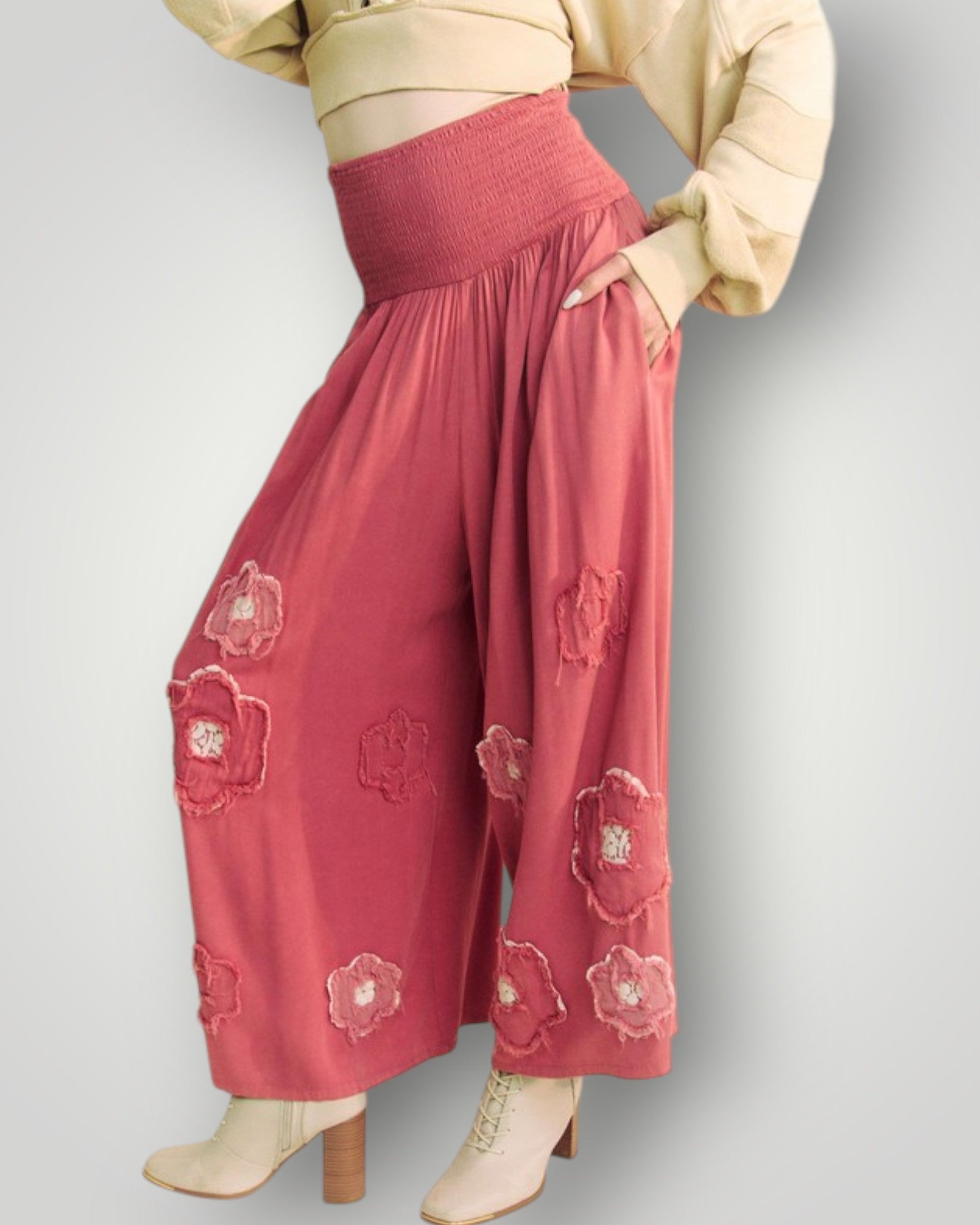 Person wearing red pants with floral patterns on a plain background