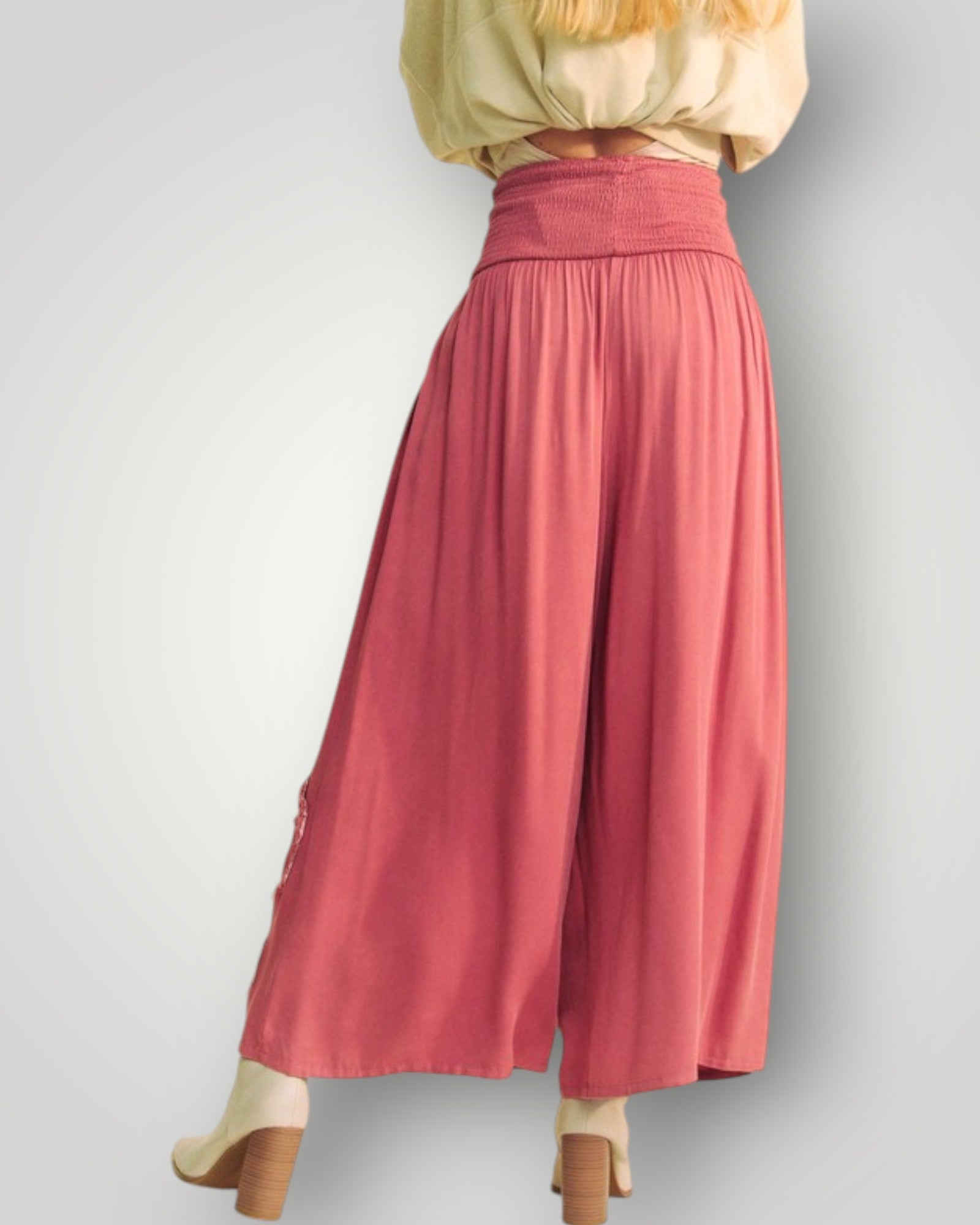 Person wearing a long pink skirt with a plain background