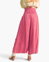 A person shown from the back wearing high-waisted, wide-leg pink pants with a matching pink waistband, paired with a light beige top and beige heels, against a plain white studio background.