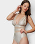 Woman wearing a beige swimsuit with mesh details on a white background