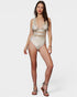 Woman wearing a beige swimsuit with mesh panels on a white background