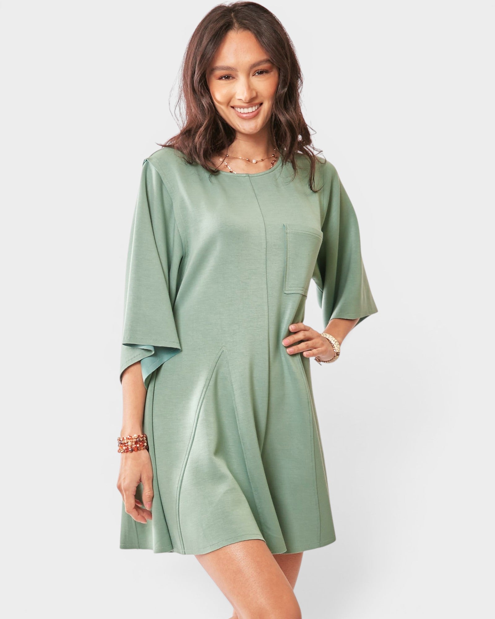 Woman wearing a green romper on a white background