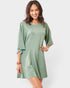 Woman wearing a green romper on a white background