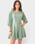Woman wearing a green romper on a white background