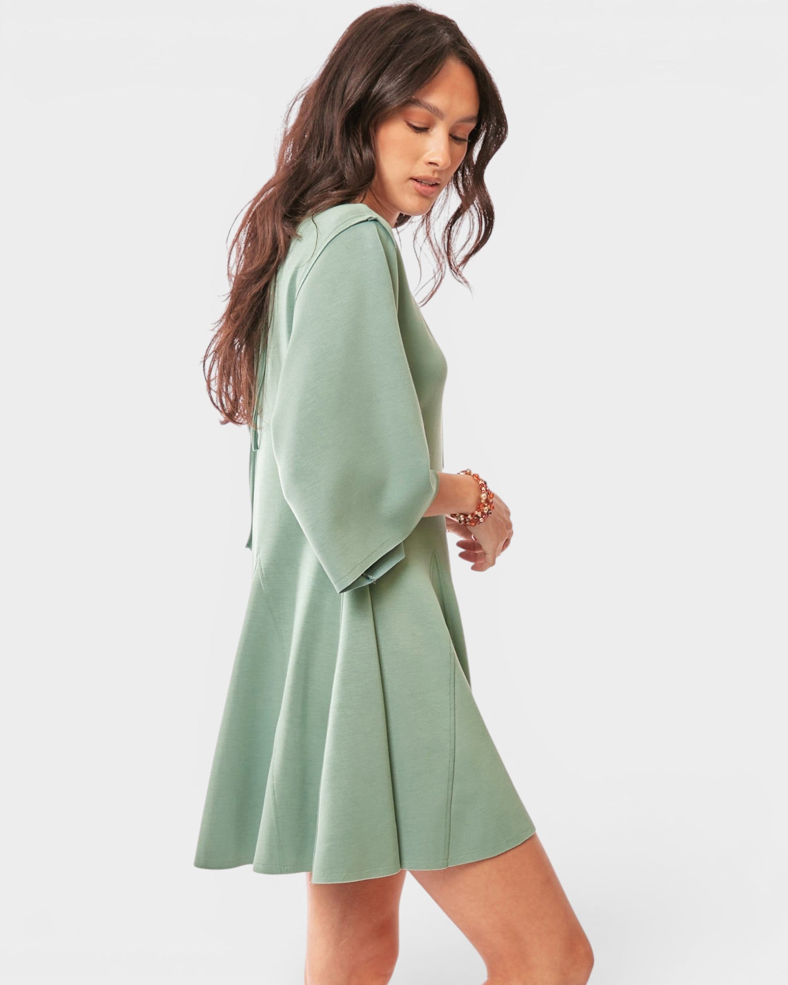 Woman wearing a light green romper on a white background