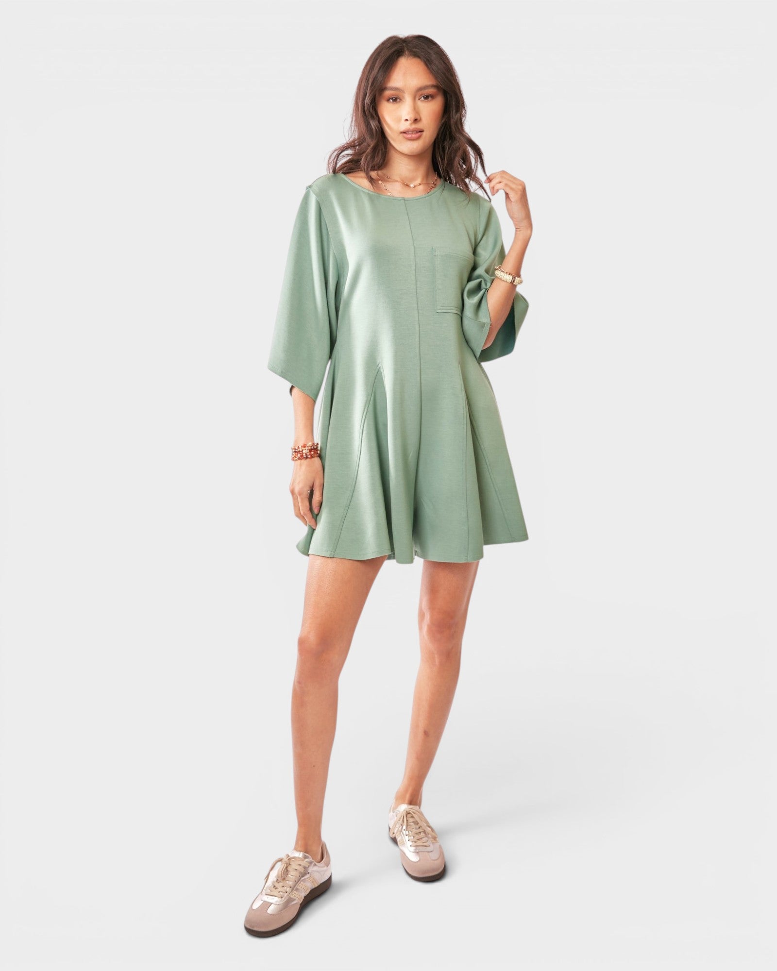 Woman wearing a green romper on a white background