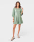Woman wearing a green romper on a white background