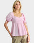 Woman wearing a pink blouse with balloon sleeves on a white background