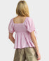 Woman wearing a pink blouse with puff sleeves on a white background