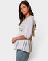 Woman wearing a light-colored blouse with ruffled details on a white background