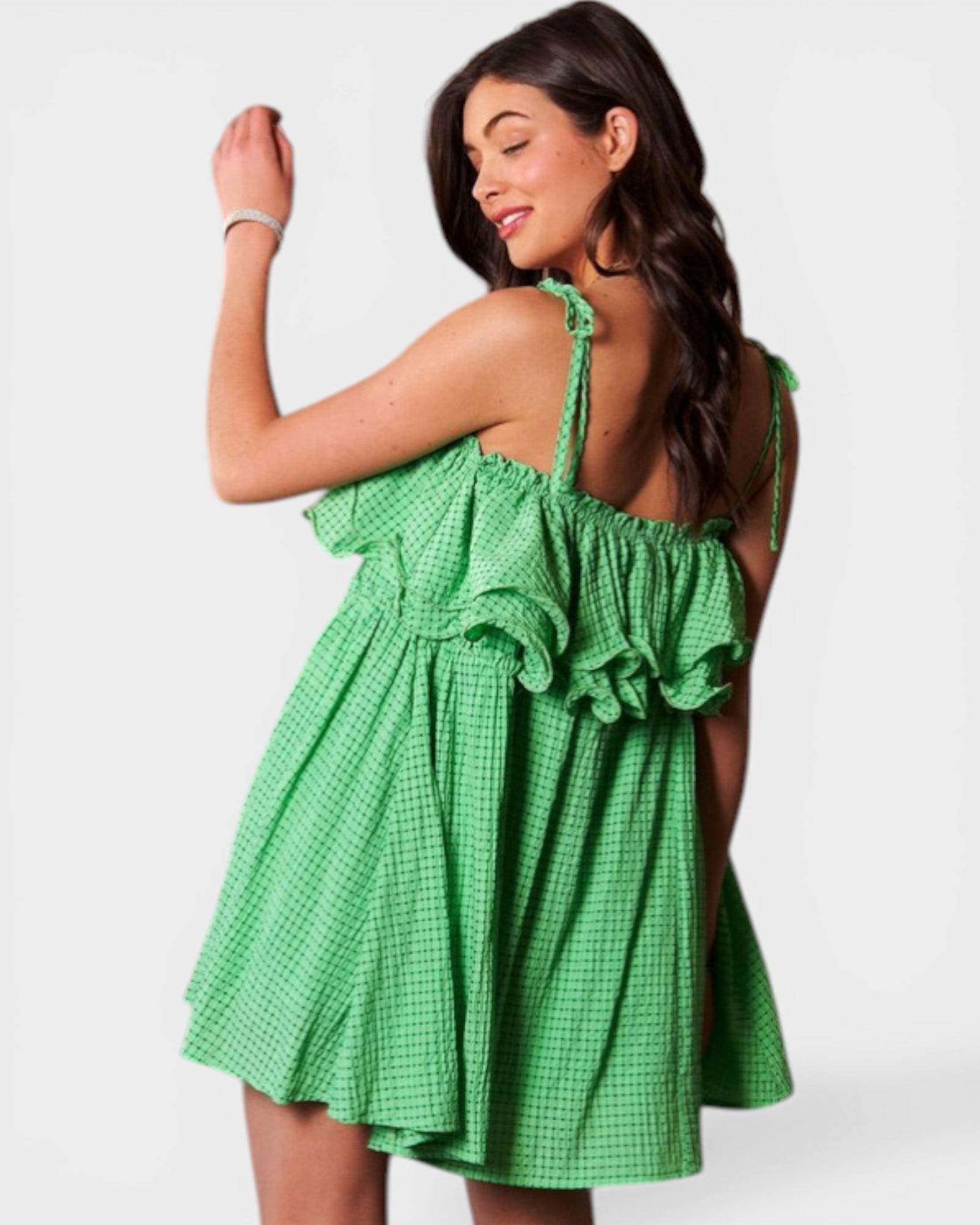 Woman wearing a green checkered dress against a white background