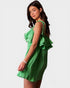 Woman wearing a green checkered dress with ruffled details on a white background