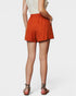 Person wearing orange shorts on a white background
