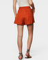 Person wearing orange shorts on a white background