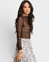 Woman wearing a sheer black top with a floral skirt on a white background