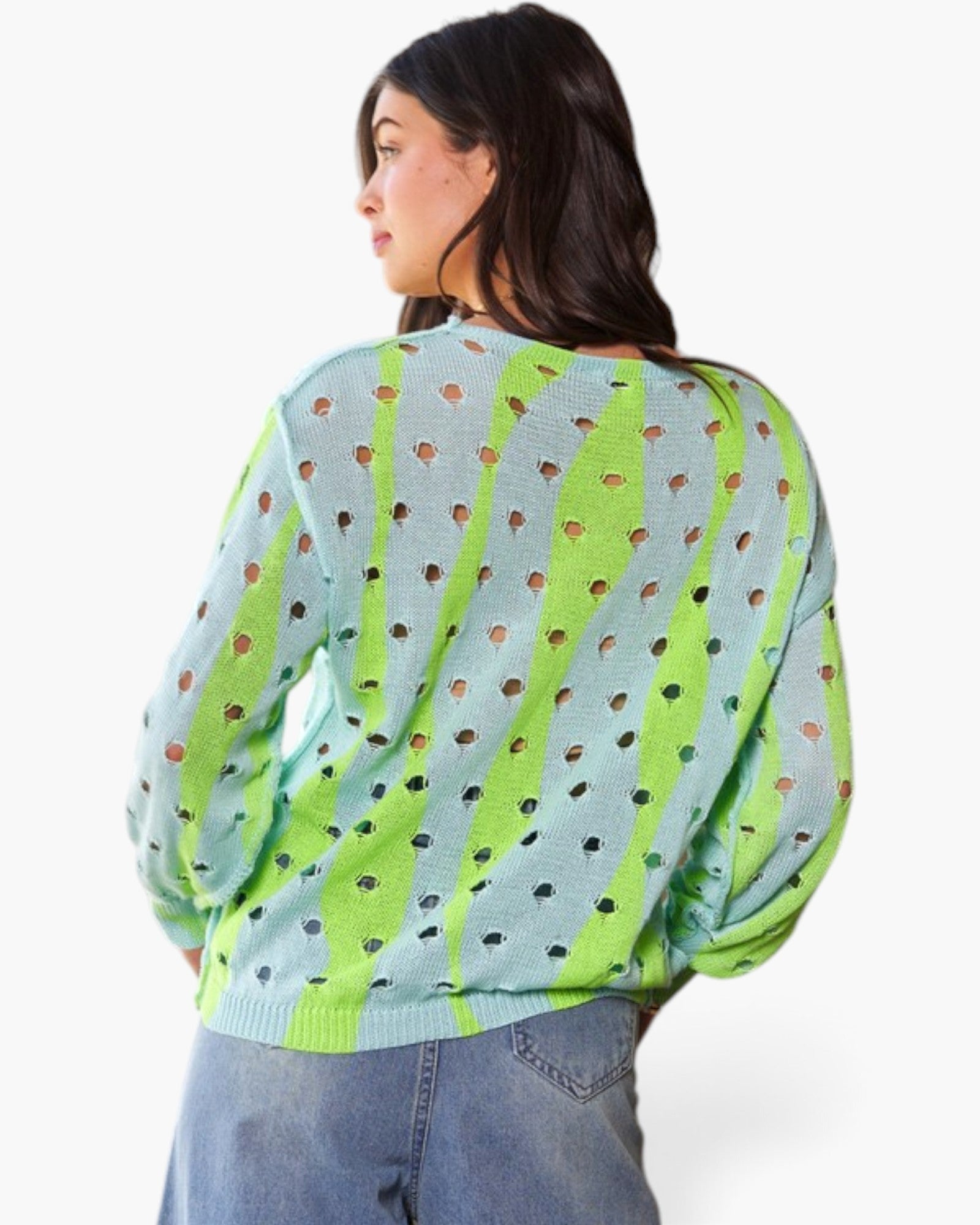 A woman shown from the back wearing a light blue knit sweater with bright lime green vertical stripes and small brown and black heart-shaped cutouts, paired with blue jeans against a plain white background.