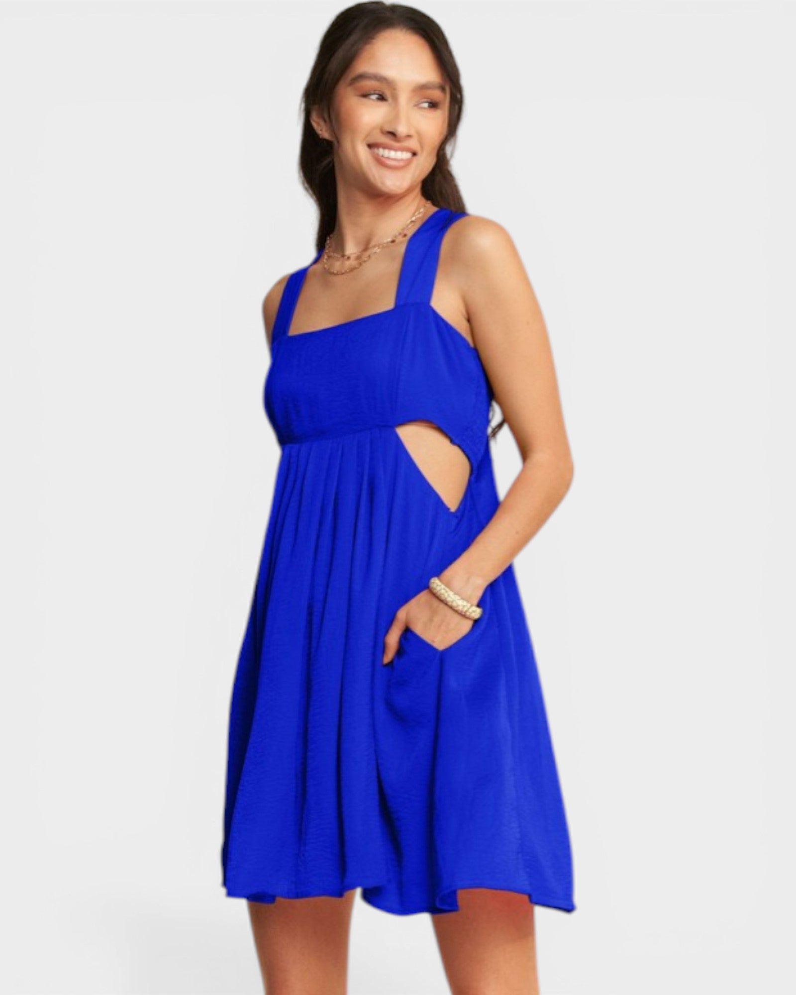Woman wearing a blue dress with cut-out design on a white background