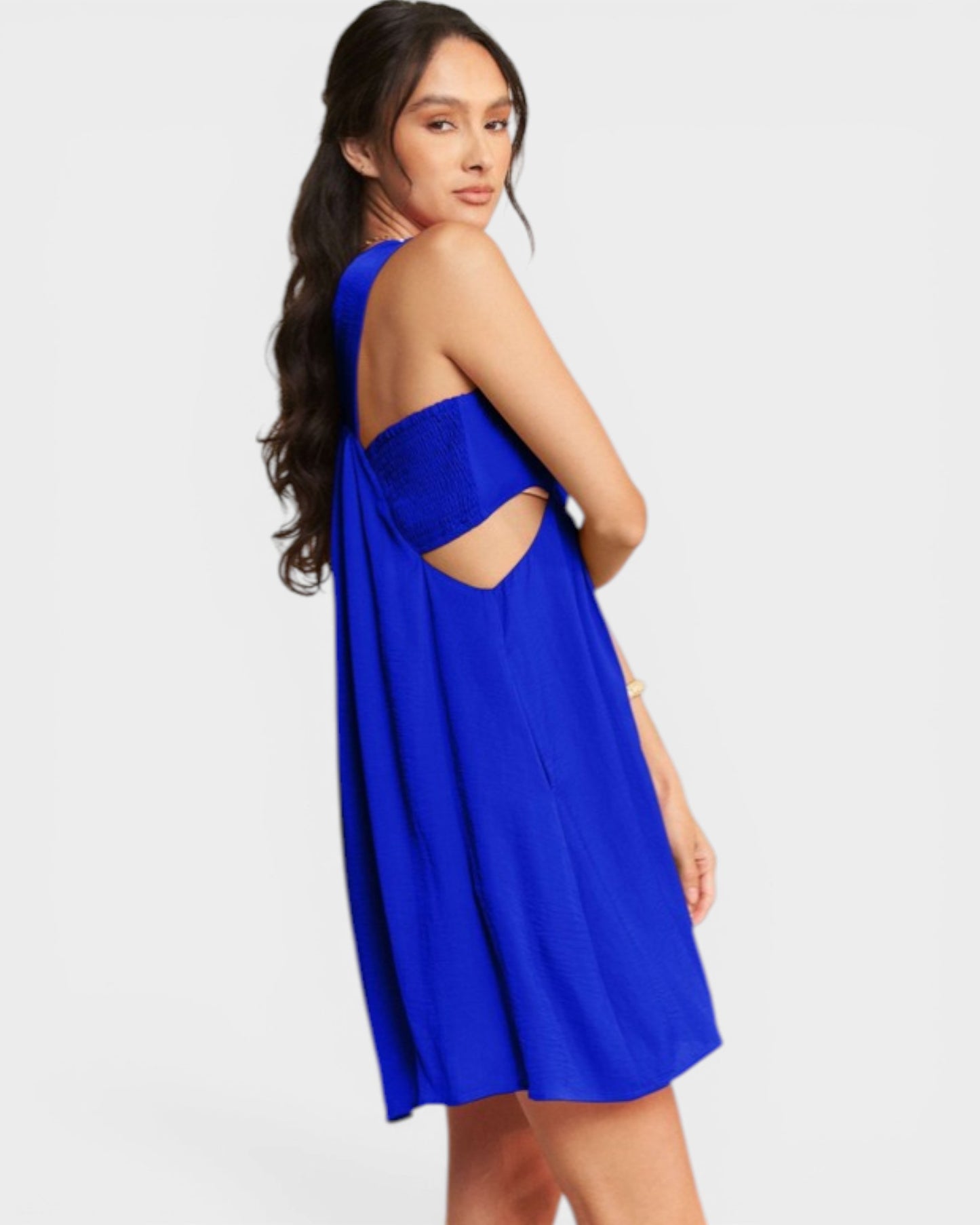 Woman wearing a blue dress with cut-out design on a white background