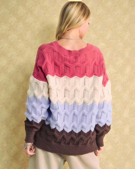 Person wearing a colorful patterned sweater against a beige background