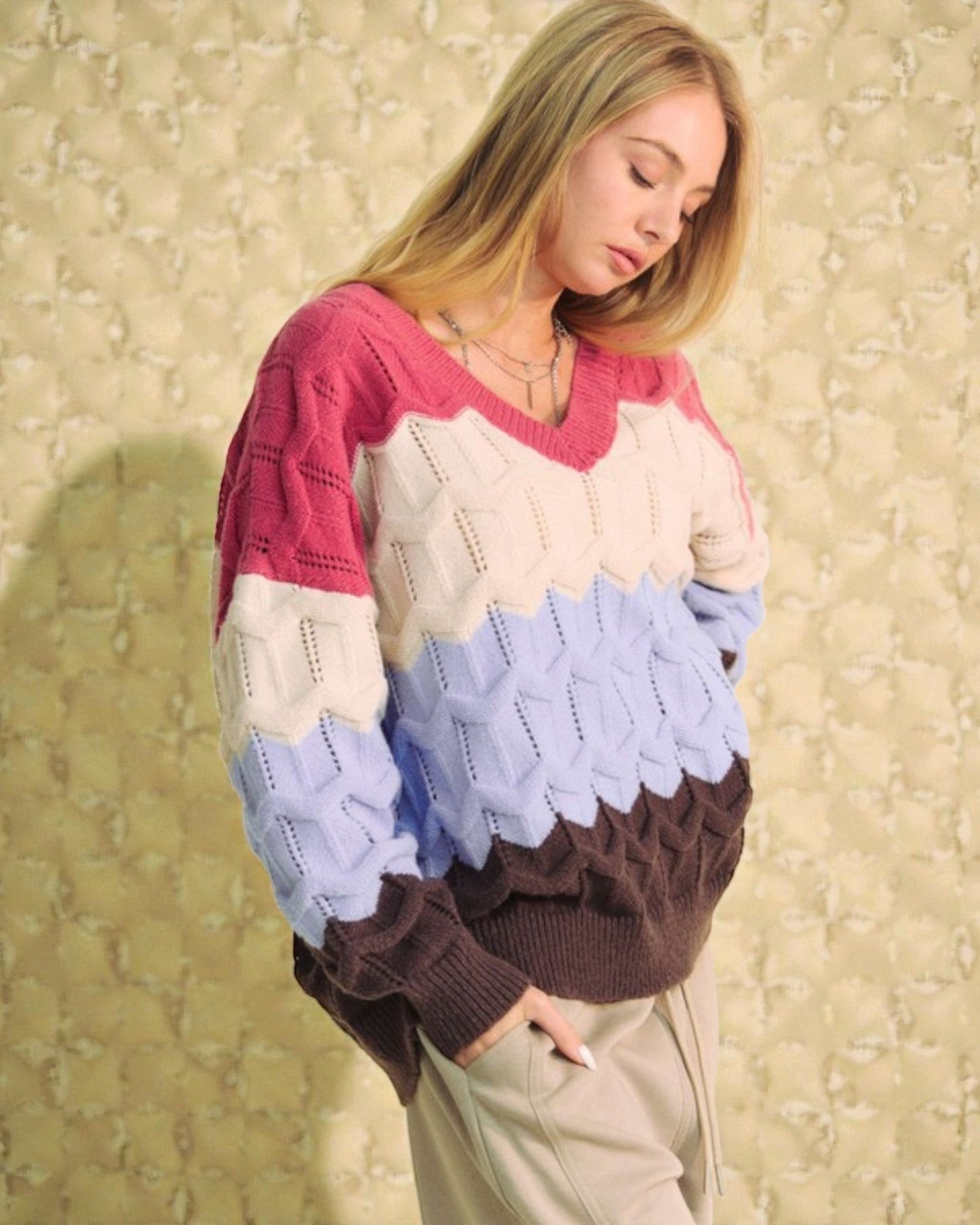 Woman wearing a colorful sweater with a patterned background