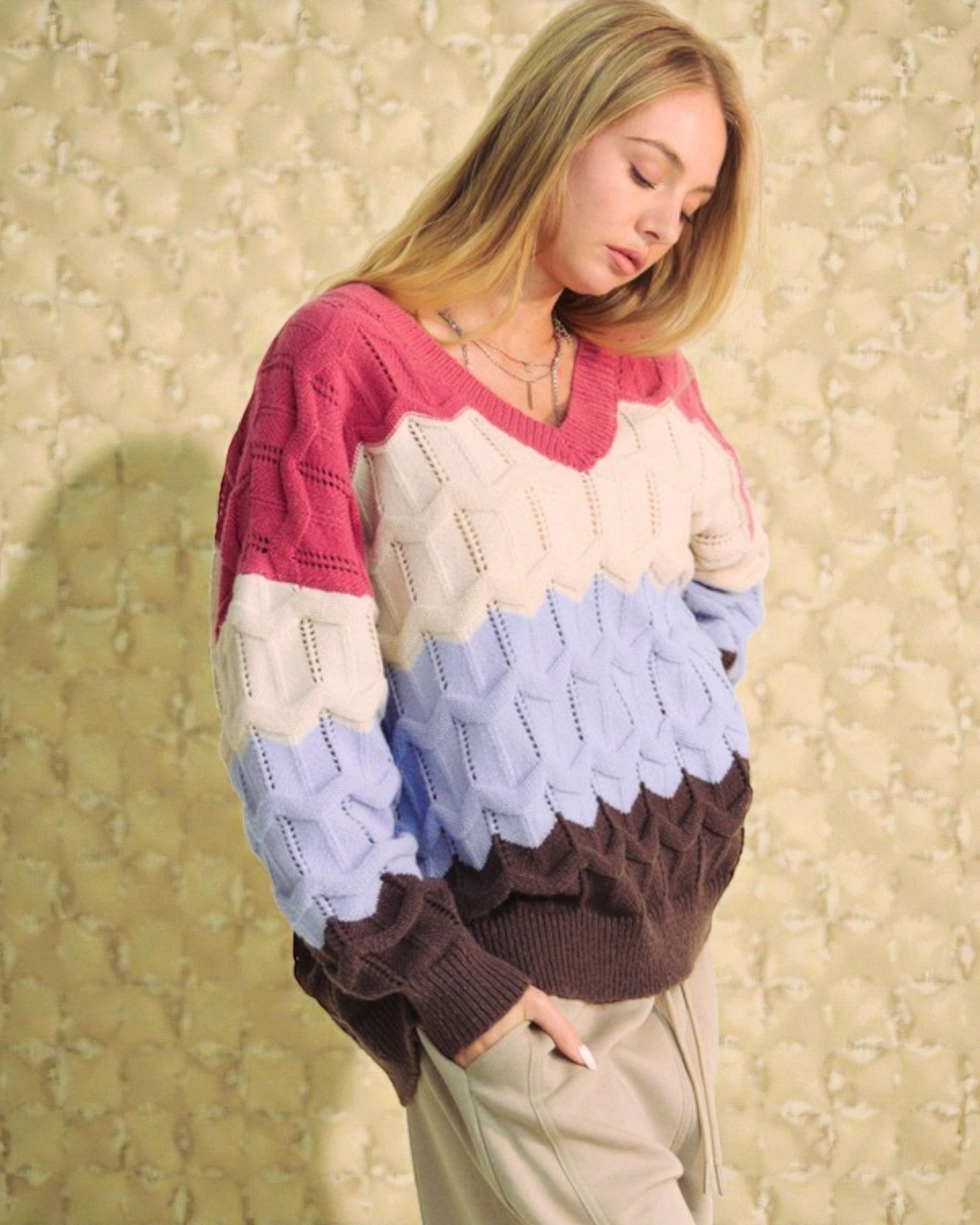 Woman wearing a colorful sweater with a patterned background