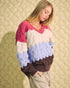 Woman wearing a colorful sweater with a patterned background